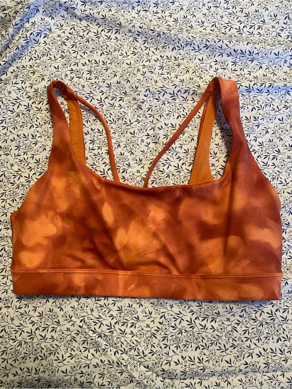 Athleta Exhale Printed Bra in a rust orange tie-dye colorway featuring a strappy